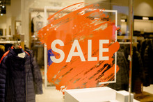 SALE Sign On The Shop's Window Display.discount Sign On Show Window. Sale Sign, Symbol In Clothes Shop,The Red Announcement Of A Fifty-percentage Discount On A Glass Show-window. Copy Space