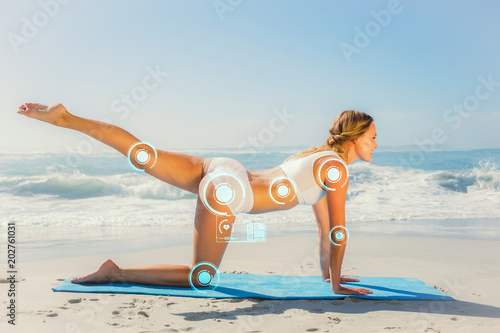 Poster Gorgeous fit blonde in pilates pose on the beach against fitness interface