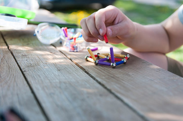 Caucasian boy playing with magnetic toys focus on the hand, on natural light.