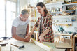 © pressmaster - Two young intercultural women measuring length of wooden plank before sawing it on workbench
