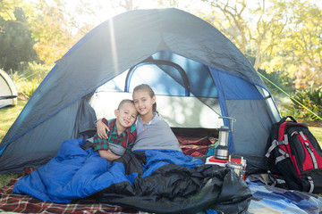 siblings sitting in the tent