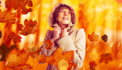 Poster - Smiling beautiful woman in winter coat looking up against view of a forest in the mist