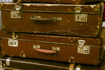 Detail of two very old brown locked suitcases