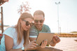 © Nebojsa - Beautiful girl and her boyfriend, wearing sunglasses and browsing internet on tablet