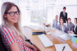 © vectorfusionart - Attractive photo editor working on computer against happy business group having a meeting