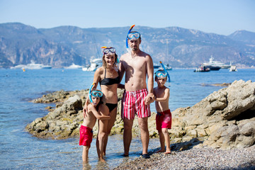 Canvas Print - Family of four with swimming equipment, ready to go diving in the sea