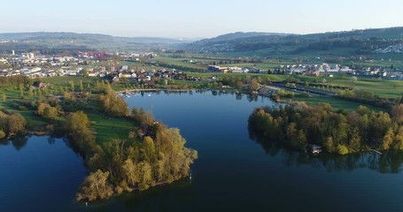 Wall Mural - Aerial view on a spring morning from the lake shore of Lake Sempach with the city of Sursee in background in central Switzerland