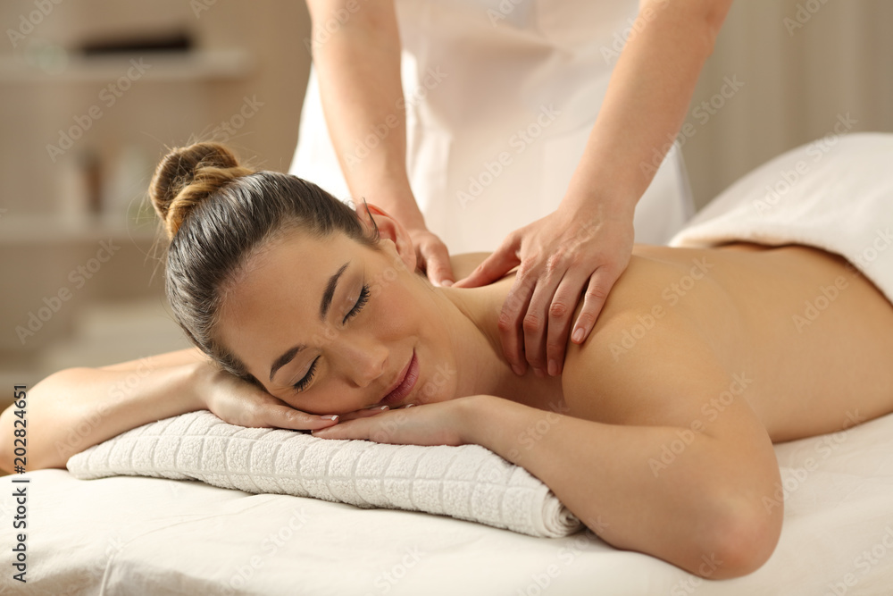 Relaxed lady receiving a massage in a spa - obrazy, fototapety, plakaty 