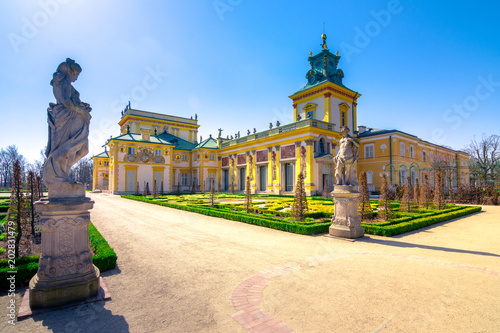 Plakat Królewski Pałac w Wilanowie w Warszawie z ogrodami, posągami i rzeką wokół niego.
