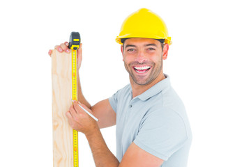 Poster - Construction worker using measure tape to mark on plank