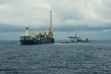 Wall Mural - dynamic positioning DP operations near FPSO tanker. Supply fleet job, DSV diving support vessel is approaching. Crewboat is coming for crewchange. Oil and gas research and production industry.