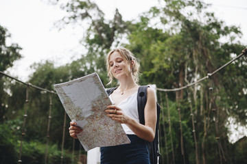 Wall Mural - Caucasian woman looking at a map travel and explore concept