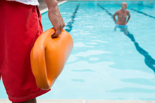 Lifeguard Holding Rescue Buoy At Poolside