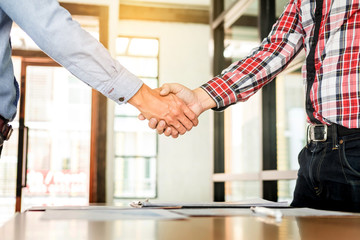 Wall Mural - Two confident business man shaking hands during a meeting in the office, success, dealing, greeting and partner concept.