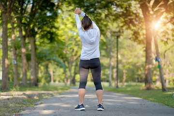 young fitness woman legs walking in the park outdoor, female runner running on the road outside, asian athlete jogging and exercise on footpath in sunlight morning. Sport,healthy and wellness concepts