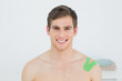 © WavebreakmediaMicro - Handsome young man with green kinesio tape on shoulder