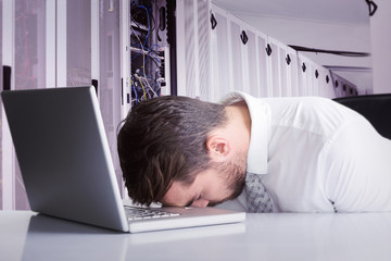 Sticker - Exhausted businessman sleeping head on laptop against data center