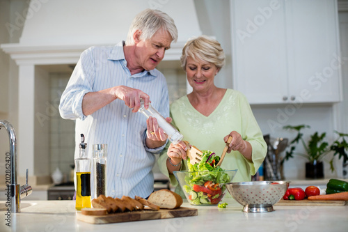 Fotografía Happy senior couple preparing vegetable salad