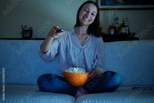 Fotografie, Obraz Young woman watching her favorite program on tv