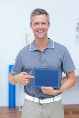 Wall Mural - Smiling doctor showing digital tablet