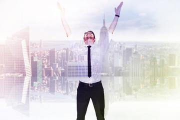 Canvas Print - Smiling businessman cheering with his hands up against room with large window looking on city