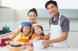 © WavebreakmediaMicro - Family of four preparing cookies in kitchen
