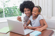 © WavebreakmediaMicro - Happy mother and daughter using the laptop
