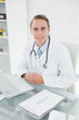 © WavebreakmediaMicro - Smiling male doctor with laptop at medical office