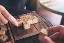 Closeup Image Of People Playing Wooden Tic Tac Toe Game Or OX Game