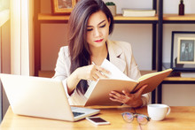 Young Asian Business Woman Working At Workplace. Beautiful Asian Woman In Casual Suit Working With Reading Book, Prepare For Meeting Or Interview In Modern Office. Freelance, Start Up Business In Asia