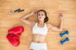 © WavebreakmediaMicro - Sporty brunette lying next to jump rope red boxing gloves and dumbbells