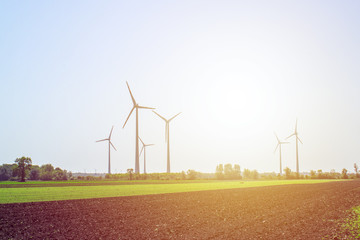 Sunny eco landscape, wind-turbines on green meadow