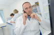 © auremar - doctor looking at the report while on the cellular phone