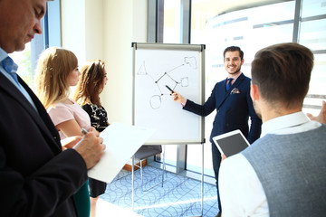 Canvas Print - Attractive businessman giving a presentation to his employees in the office.