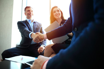 Wall Mural - Business people shaking hands, finishing up a meeting.