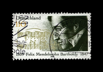 Jakob Ludwig Felix Mendelssohn Bartholdy (1809-1847), famous German composer, pianist, author of Wedding March, circa 1997. Vintage postal stamp printed in Germany isolated on black background.