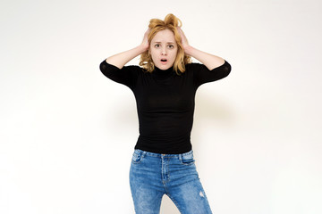 Portrait of a beautiful blonde girl on a white background showing surprise and delight.