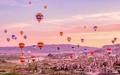 Colorful hot air balloons flying over rock landscape at Cappadocia Turkey