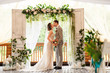 © Wedding photography - Wedding ceremony. Elegant wedding couple kissing near wedding arch, bride and groom in love