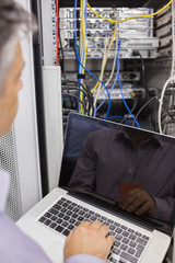 Aufkleber - Man sitting with a laptop in front of a server