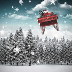 Poster - Santa flying his sleigh against snowy landscape with fir trees