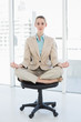 © WavebreakmediaMicro - Focused chic businesswoman sitting in lotus position on her swivel chair