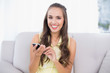© WavebreakmediaMicro - Happy pretty brunette holding smartphone