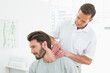 © WavebreakmediaMicro - Male therapist massaging a young mans neck