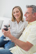 © WavebreakmediaMicro - Relaxed couple with wine glasses sitting on sofa