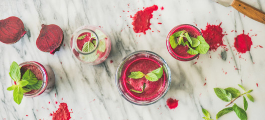 Fresh morning beetroot smoothie or juice in glasses with mint leaves, grey marble background, top view. Healthy vegan, vegetarian breakfast, seasonal detox, alcaline diet, weight loss food concept