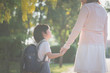 © lalalululala - Mother holding hand of little son with backpack outdoors, back to school