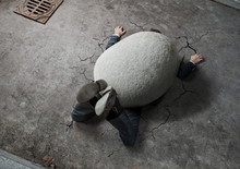 High Angle View Of Businessman Crushed By The Huge Stone On The Street With Copy Space