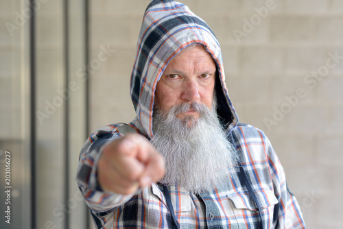 Poster Stern man wearing a hooded top pointing with his finger with focus to his face
