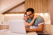 © Nebojsa - Young man with glasses is working on his laptop while his girlfriend is hugging him